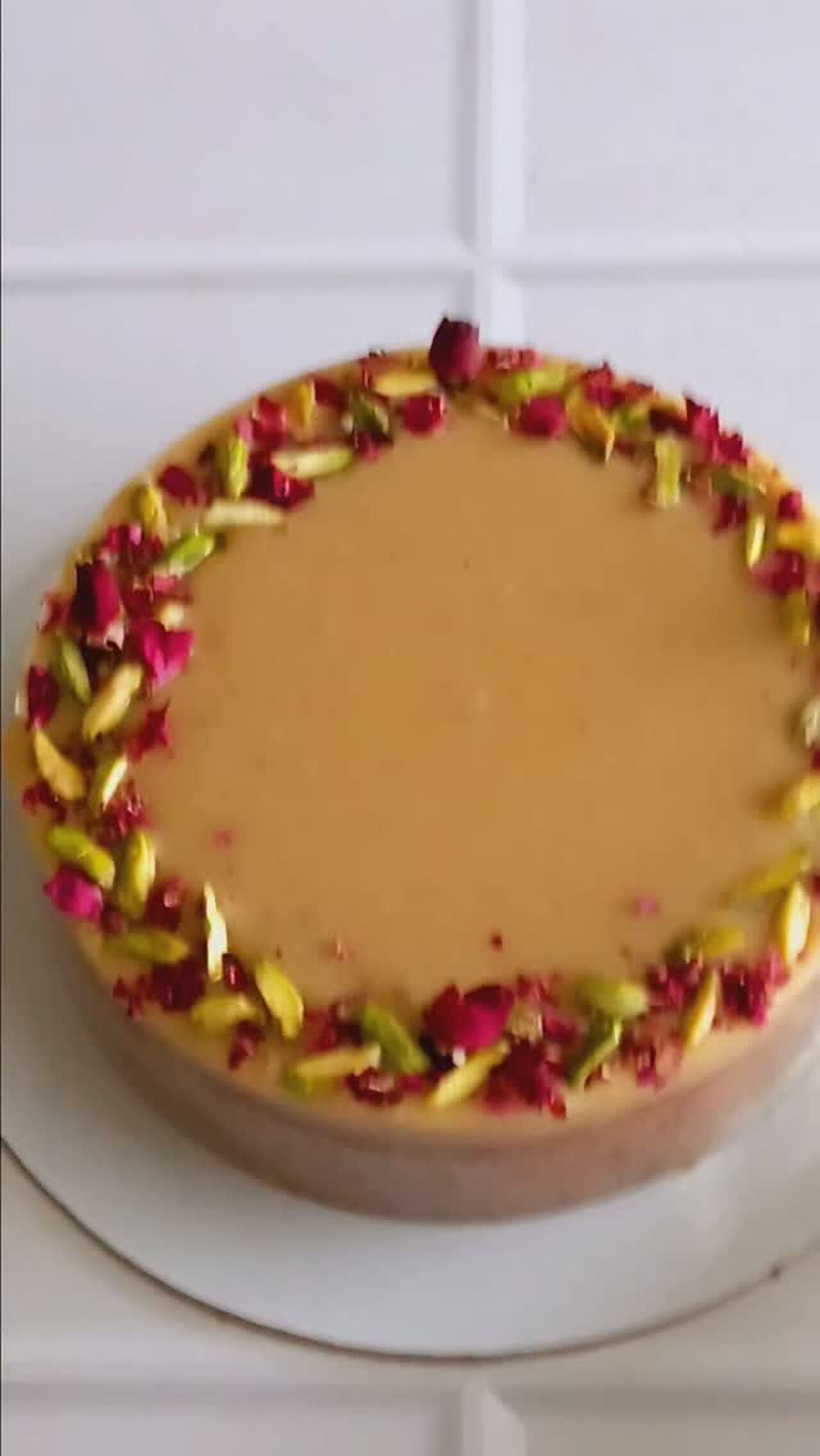Caramel cake crowned with pistachios and rose petals